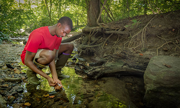 Austin Gray collects water samples