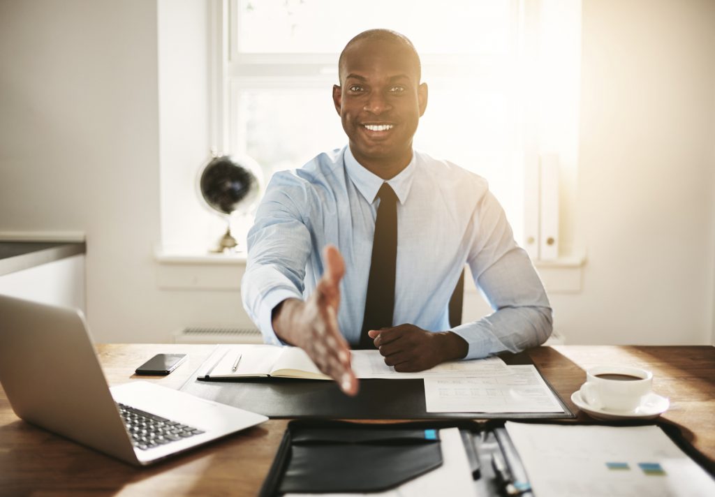 smiling young executive sitting at his desk preparing for job interviews