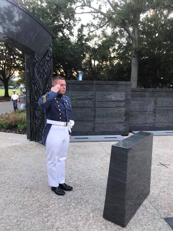 Cadet Caleb Carter on Ring Day at The Citadel War Memorial saluting alumni killed in action