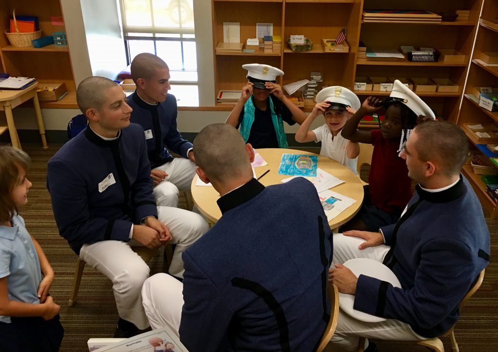 Freshmen cadets teach James Simons elementary school children about heroes and help them make cards