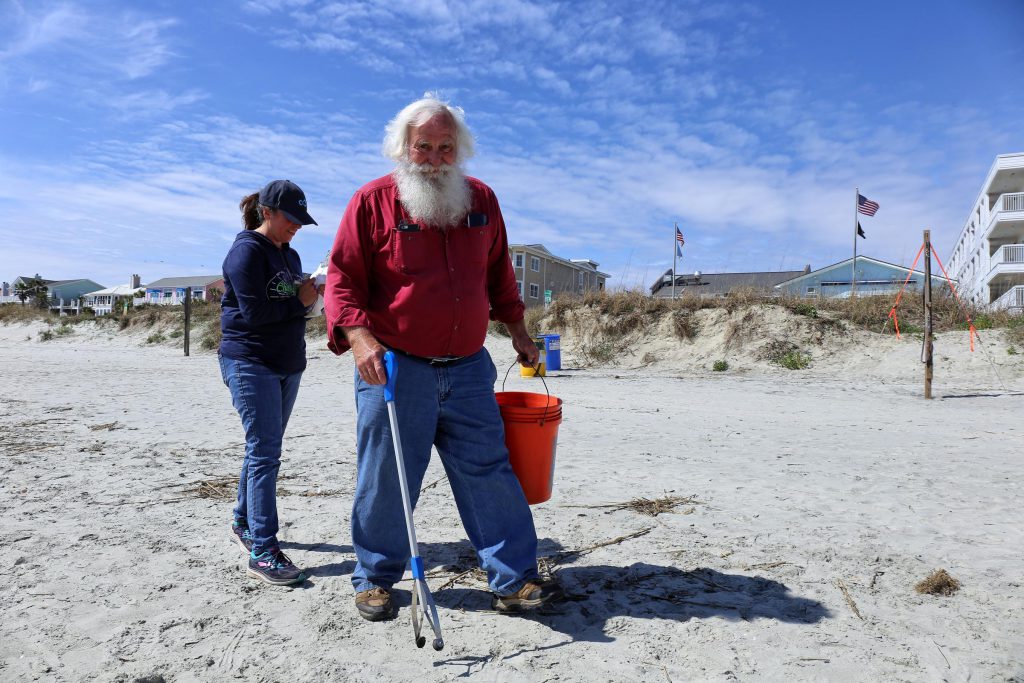 Howard Hogue, known as Beach Santa, and Linda Rowe pick up litter on the Isle of Palms (Courtesy: Victoria Hansen, SC Public Radio)