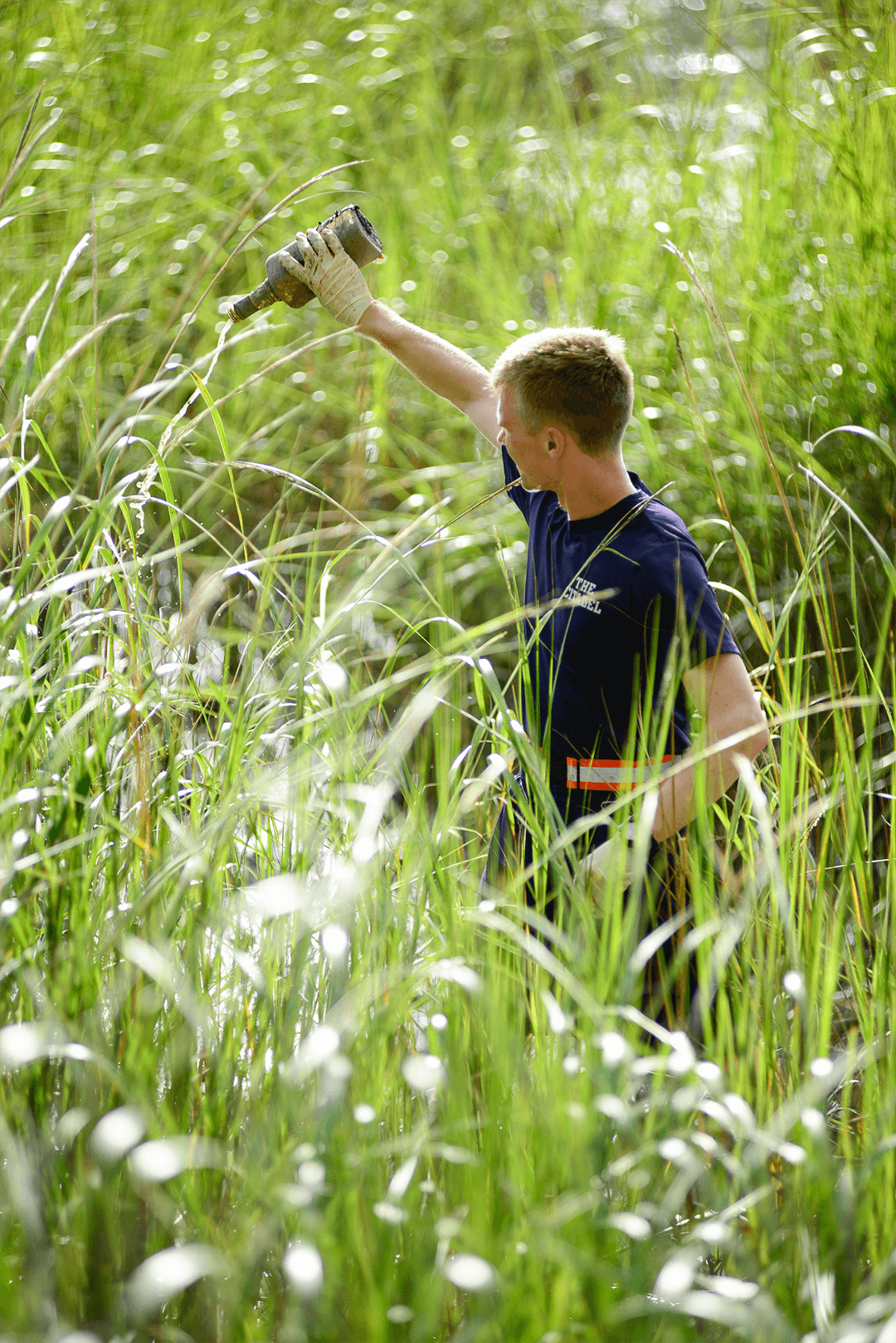 Matthew Miller, '19, participates in an effort to remove trash from the marsh.