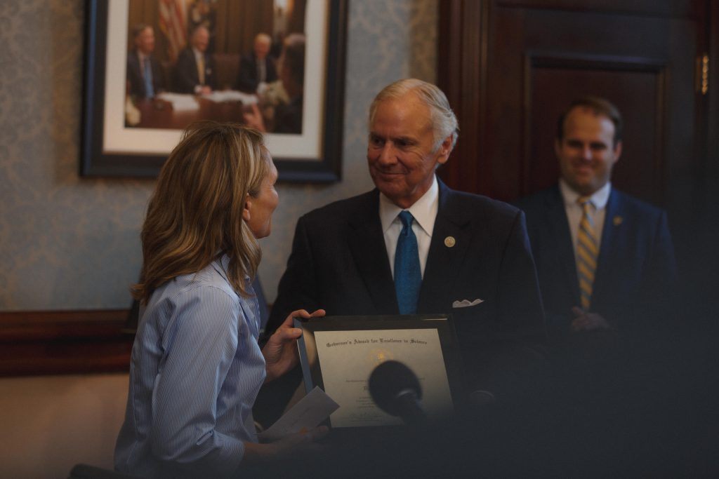 Governor Henry McMaster presents Dr. Dena Garner, The Citadel's director of research, an award of excellence