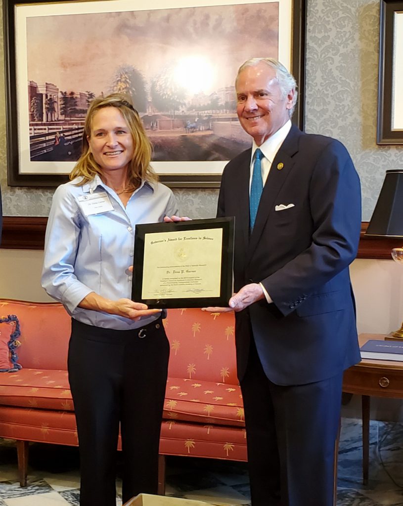 Governor Henry McMaster presents Dr. Dena Garner, The Citadel's director of research, an award of excellence