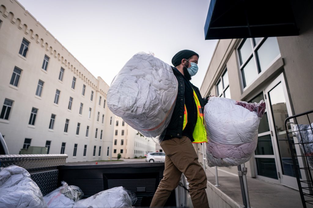 Christopher Jardin, the community liaison and homelessness coordinator for the City of Charleston, unloads laundry from the city’s warming centers at the Cadet Laundry at The Citadel in Charleston, South Carolina on Wednesday, December 2, 2020. (Photo by Cameron Pollack / The Citadel)