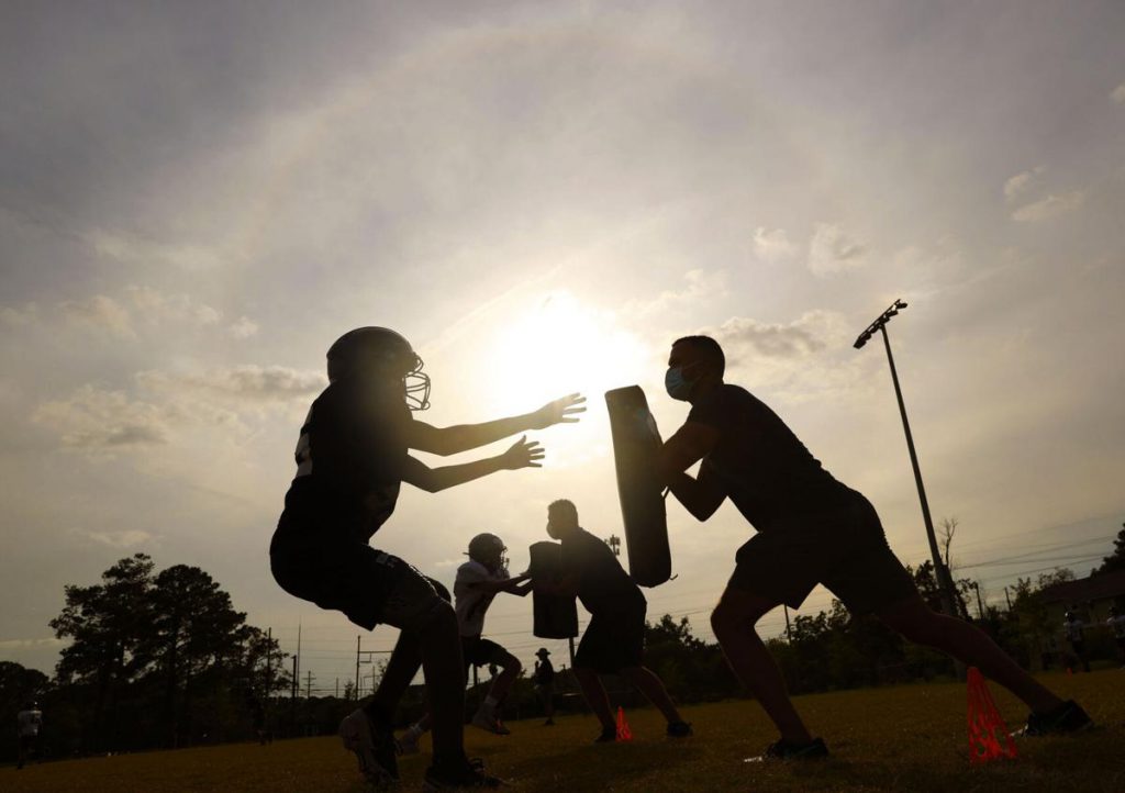 Post and Courier photo of Lucy Beckham HIgh school football players practicing in summer