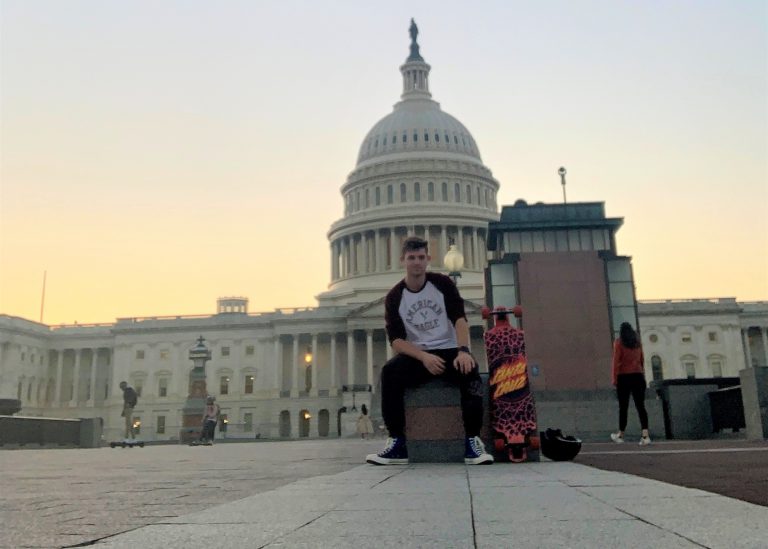 David James Hardcastle, with his skateboard, sitting in front of the national capitol